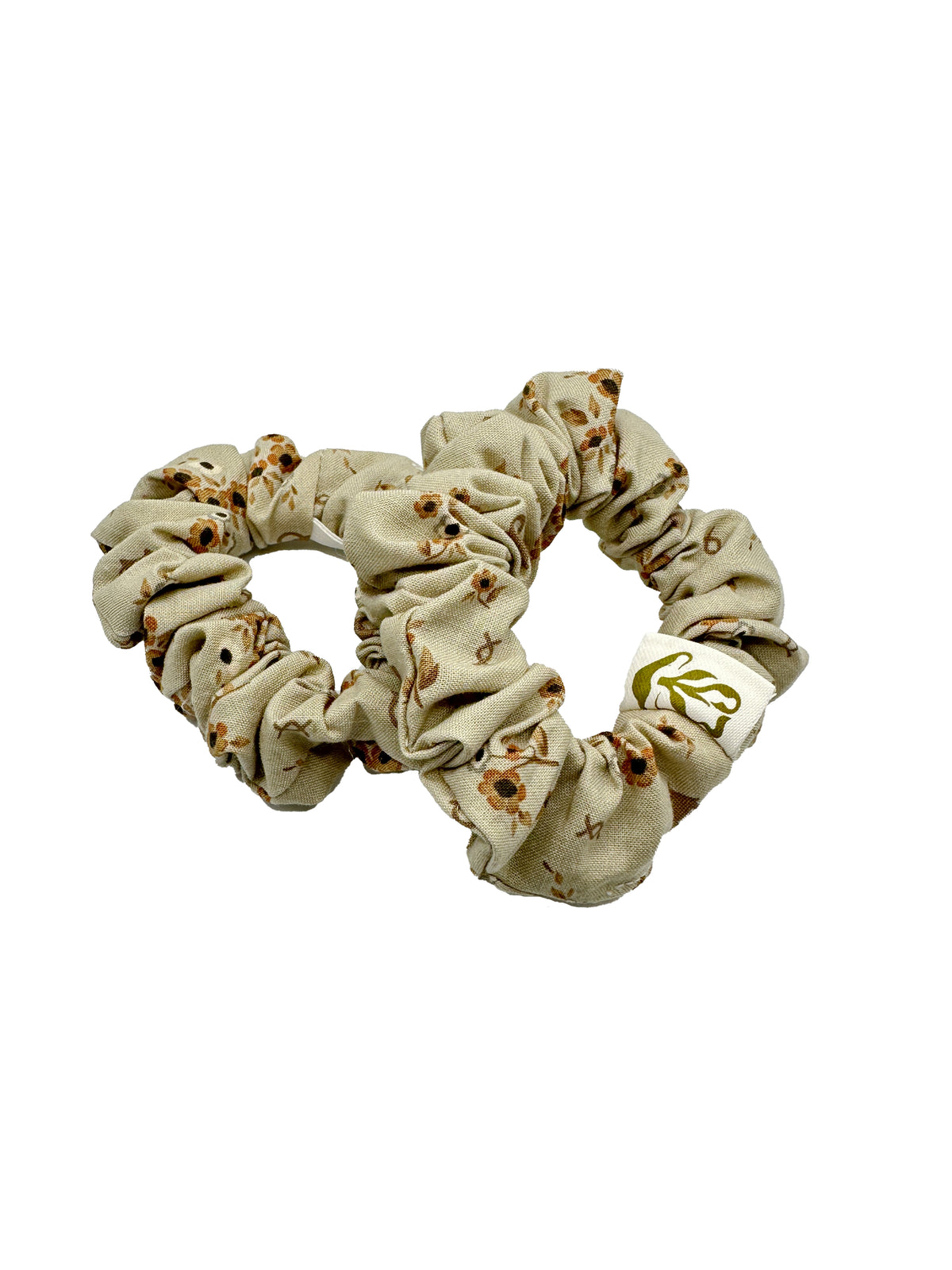 Beige scrunchie with floral pattern on a white background